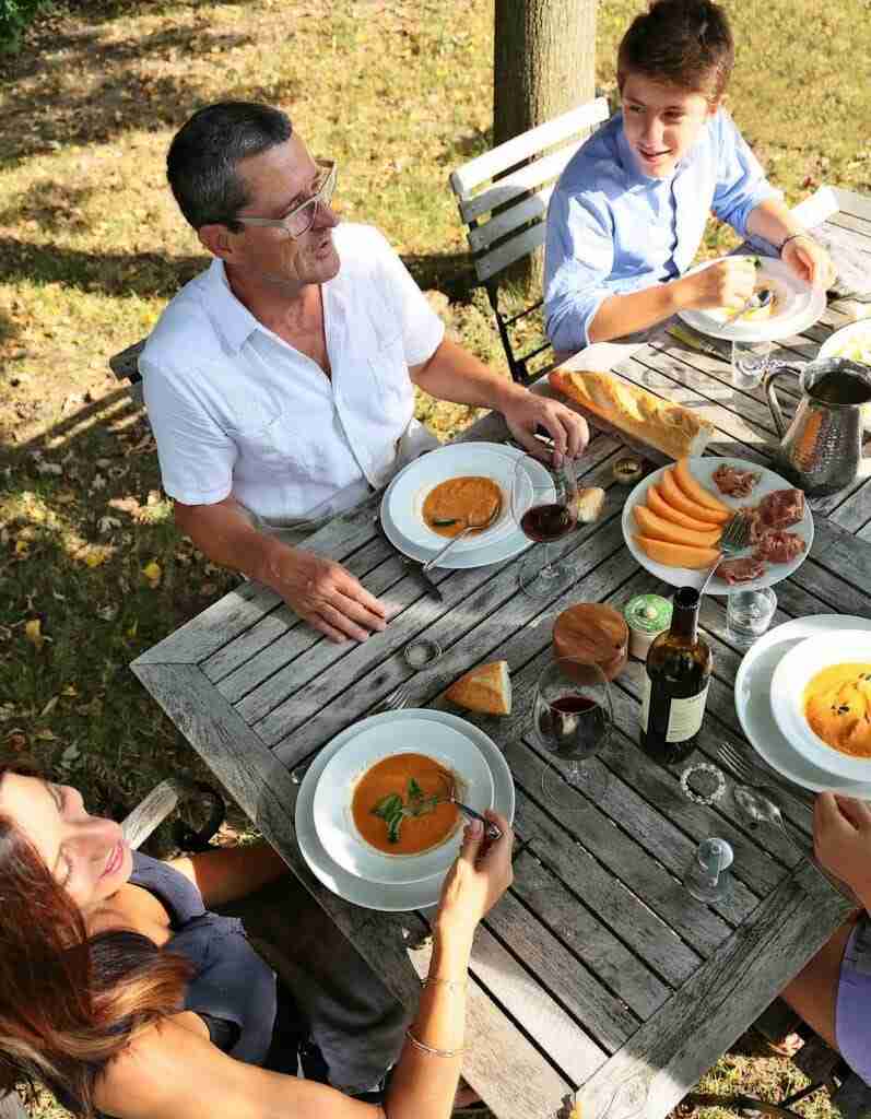 Caterina DeFalco and her family eating at their table outside; Return to the Table with easy family dinner ideas