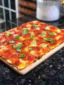 a square pizza on a wooden board