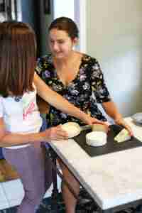 Adriana helping Caterina assemble a cheese tray for dessert